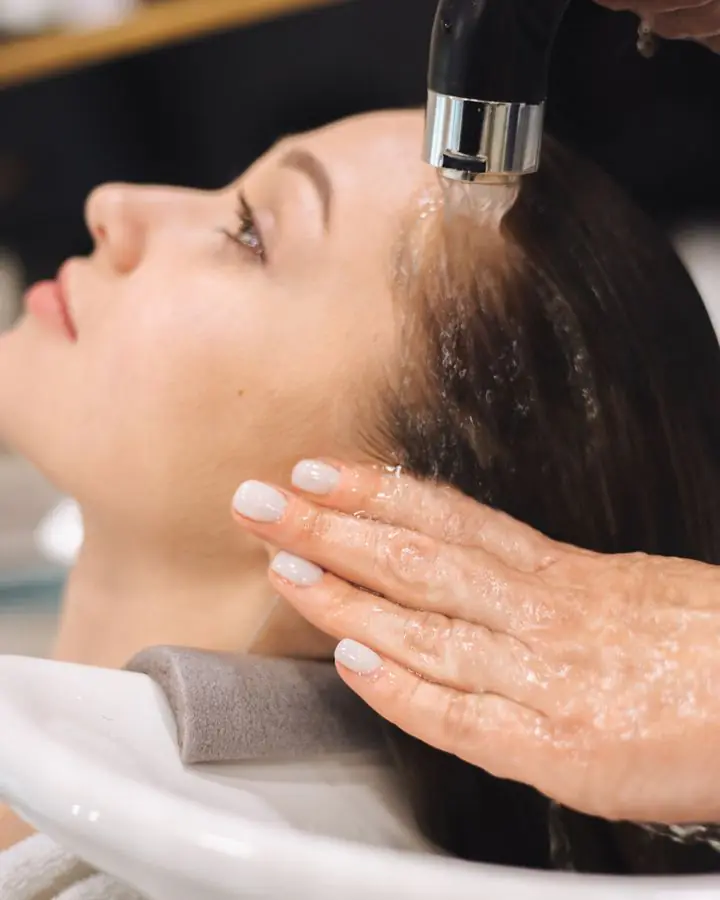 Client relaxing at the wash basin during a hair spa