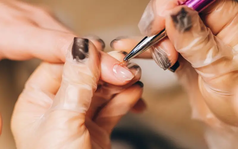 Manicurist painting nails during a manicure