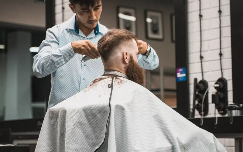 Stylist finishing a men’s cut in the salon