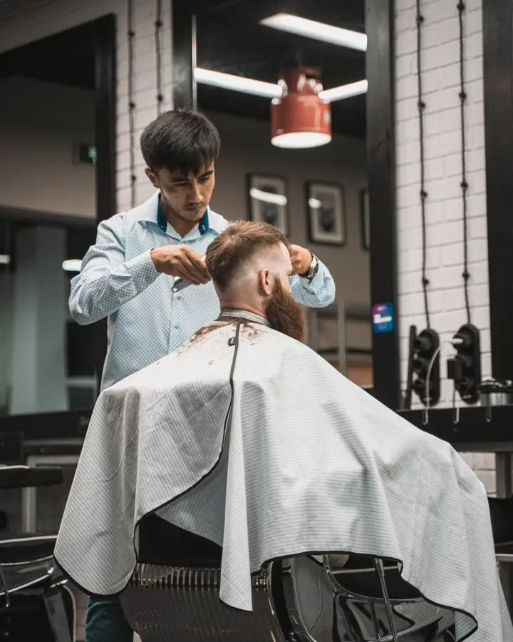 Stylist finishing a men’s cut in the salon