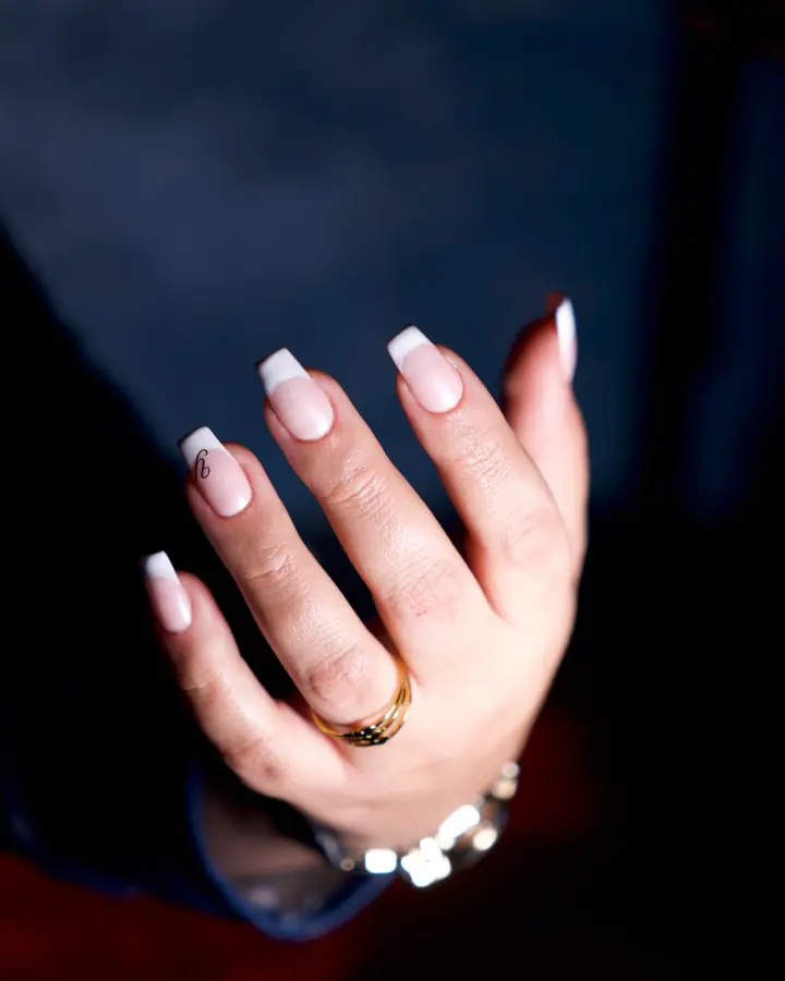 Almond nails with jewellery and a soft nude finish