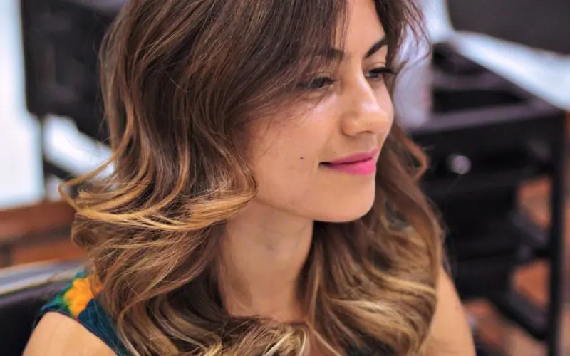 Client with curly ombré hair sitting in the salon
