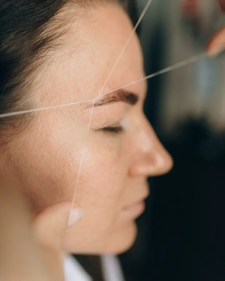 Side view of an eyebrow threading session