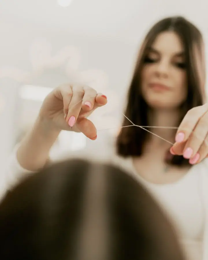 Beautician threading a client’s brows