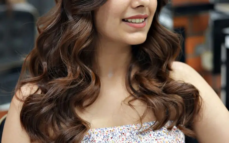 Woman with soft brunette waves in the salon